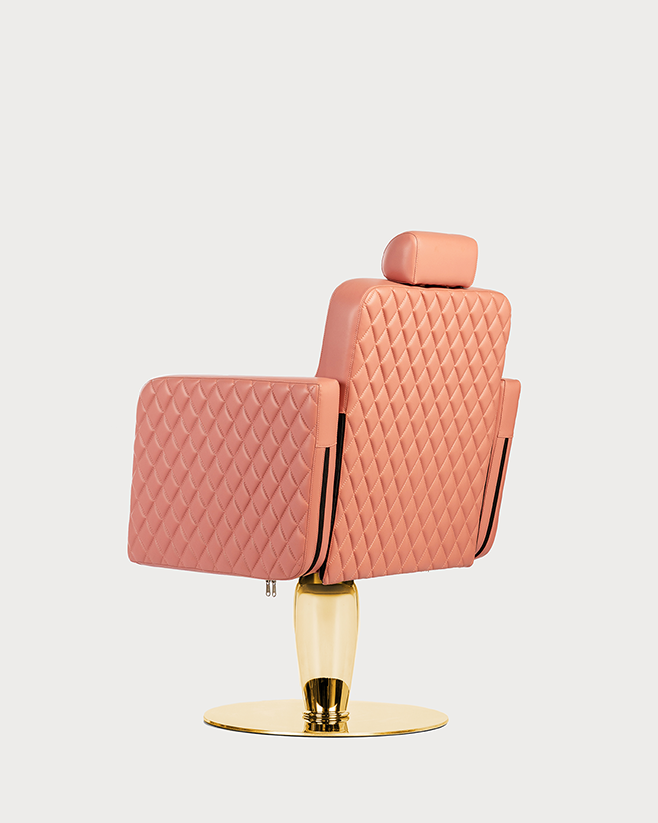 A professional pink salon chair with a quilted backrest and seat, featuring a gold chrome base and adjustable height mechanism.