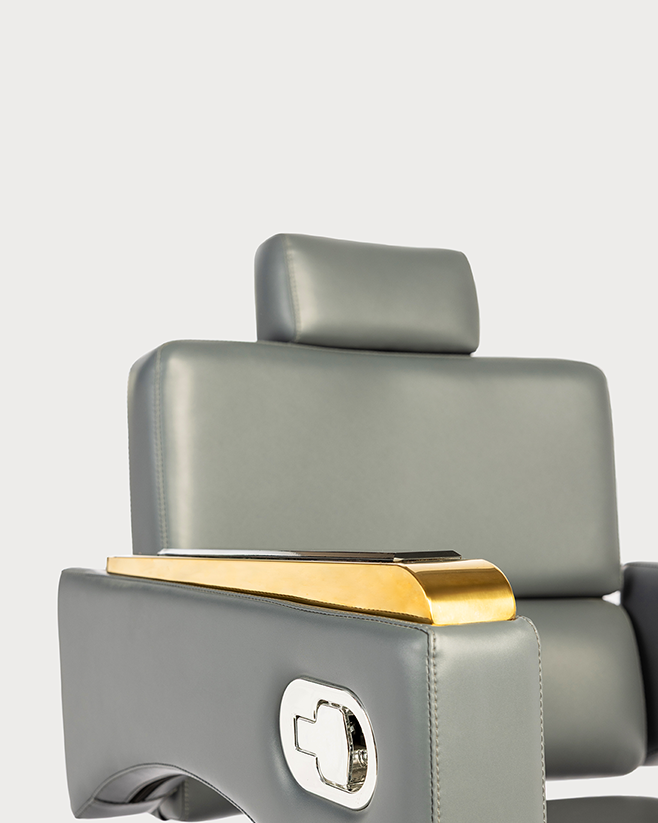 Gray barber chair with gold accents on a white background