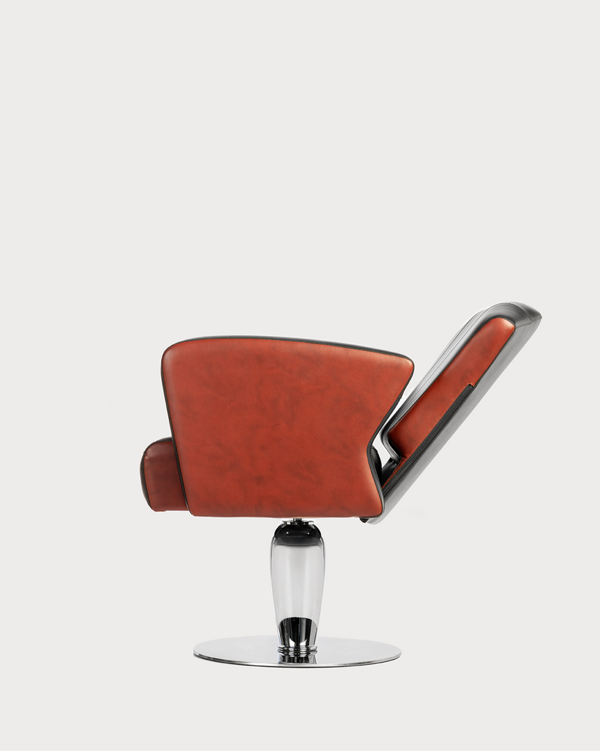 A professional hair salon styling chair with orange upholstery and a chrome base.